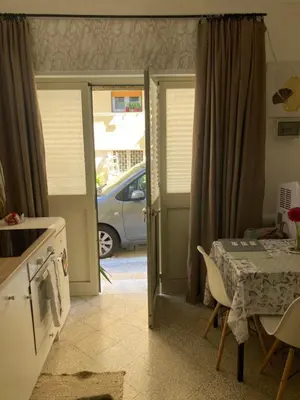 a kitchen with a table and a door to a car at Casteldaccia Stay, mieszkanko Kingi in Casteldaccia