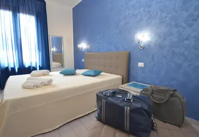 a bedroom with a bed with a bag on it at Le Falesie di Castelluzzo in Castelluzzo