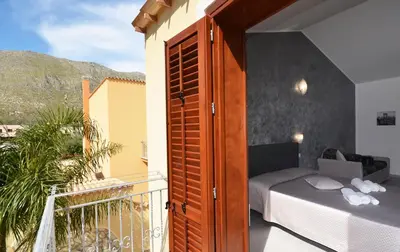 a bedroom with a bed on a balcony at Le Falesie di Castelluzzo in Castelluzzo