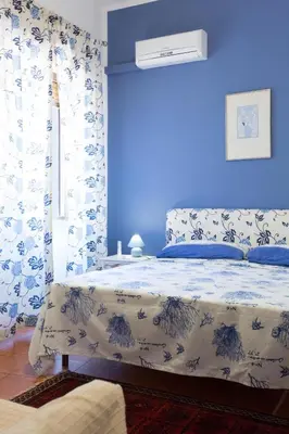 a blue bedroom with a bed with a blue wall at Villa Soliva - Mare e Panorama Unico in Mondello