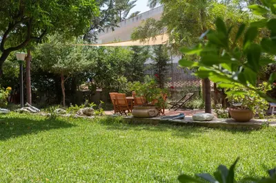 a garden with two chairs and a bench in the grass at Villa Soliva - Mare e Panorama Unico in Mondello