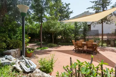 a patio with a table and chairs under aige umbrella at Villa Soliva - Mare e Panorama Unico in Mondello