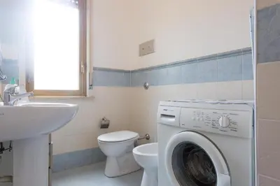 a bathroom with a washing machine and a toilet at Villa Soliva - Mare e Panorama Unico in Mondello