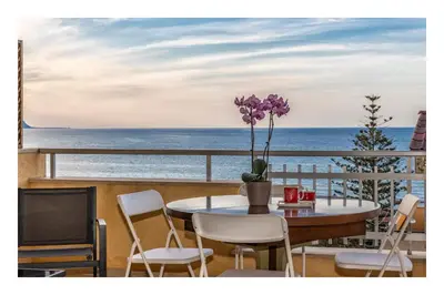 a table and chairs on a balcony with the ocean at Battigia SOLEMAR-Alcamo Marina in Alcamo Marina