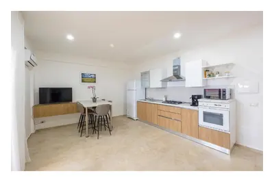a kitchen with white appliances and a table with chairs at Battigia SOLEMAR-Alcamo Marina in Alcamo Marina