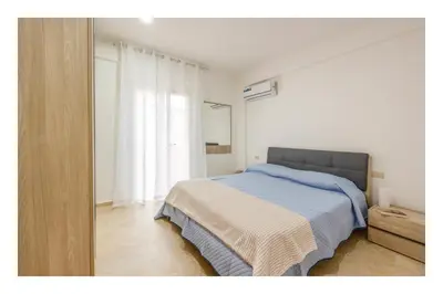 a white bedroom with a bed and a window at Battigia SOLEMAR-Alcamo Marina in Alcamo Marina