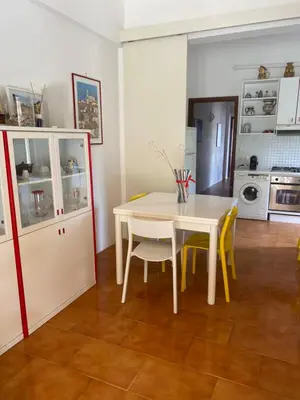 a kitchen with a white table and yellow chairs at Scopello Beach in Scopello