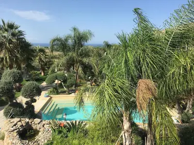 a view of a swimming pool with palm trees at Villa with private pool and wonderful view in Carini