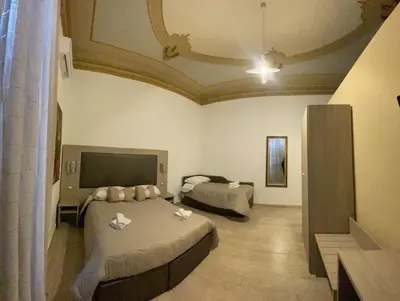 a hotel room with two beds and a tv at Alberto1 in Palermo