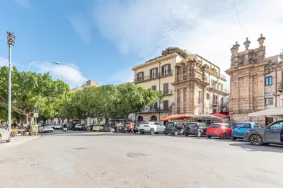 a street with cars parked on the side of the road at Kadì Apartment by Wonderful Italy in Palermo