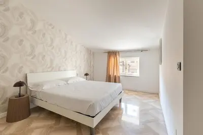 a white bedroom with a bed and a staircase at Kadì Apartment by Wonderful Italy in Palermo