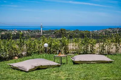 two pillows and a table in a yard with a fence at VILLA AGLEA Luxury By Sicily Home Solutions in Castellammare del Golfo