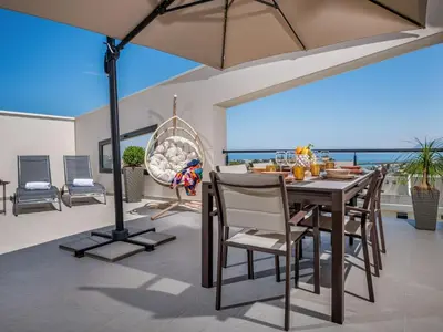a dining room with a table and chairs and the ocean at Apartment Attico Dolce Vista by Interhome in Castellammare del Golfo