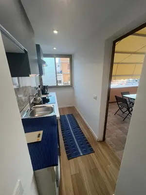 a kitchen with a sink and a table with chairs at GFL Mondello - Appartamenti vista mare in Mondello
