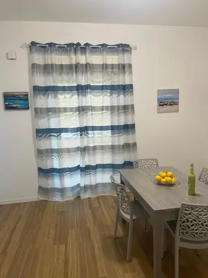 a dining room with a table and a curtain at GFL Mondello - Appartamenti vista mare in Mondello