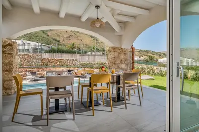 an outdoor dining room with a table and chairs at Villa Hemèra Luxury By Sicily Home Solutions in Castellammare del Golfo