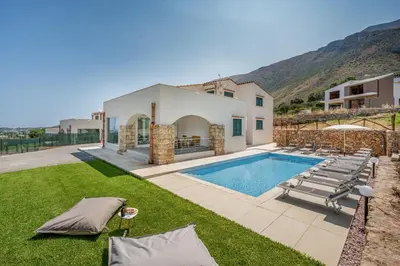 a villa with a swimming pool and lounge chairs at Villa Hemèra Luxury By Sicily Home Solutions in Castellammare del Golfo