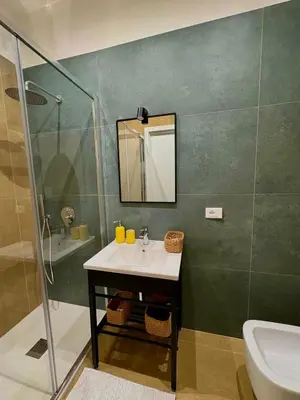 a bathroom with a sink and a shower and a mirror at Renda36 in Carini