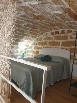 a bed in a room with a brick wall at Relaxing Room in Terrasini