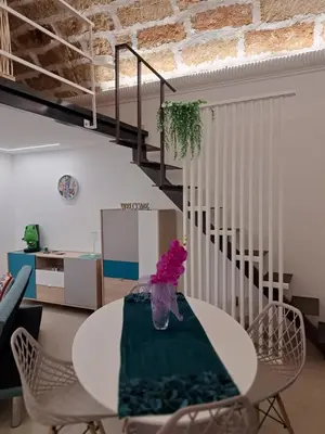 a white table and chairs in a room with a staircase at Relaxing Room in Terrasini