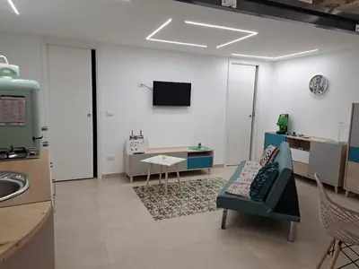 a living room with a couch and a table and a tv at Relaxing Room in Terrasini