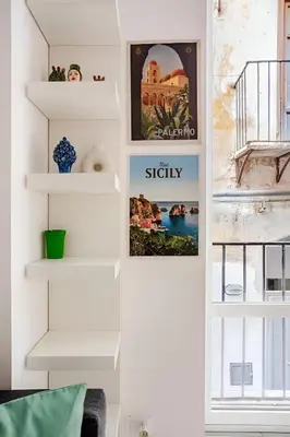 a room with white shelves and posters on the wall at Casa Bellini in Palermo