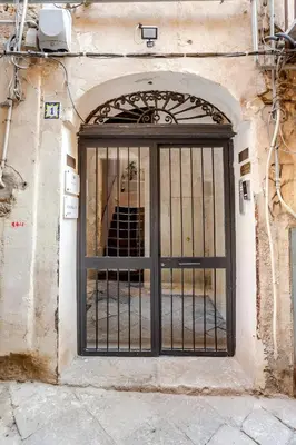 an entrance to a building with a gate at Casa Bellini in Palermo