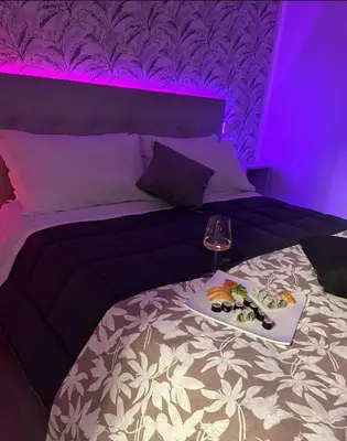 a purple room with a bed with a tray of food on it at Florio Suite Apartment in Palermo