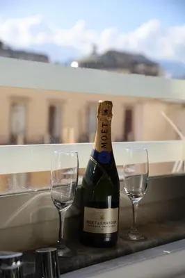 a bottle of wine and two glasses on a ledge at Florio Suite Apartment in Palermo