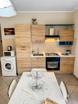 a kitchen with a table and a sink and a stove at Onda Blu Apartment in Balestrate