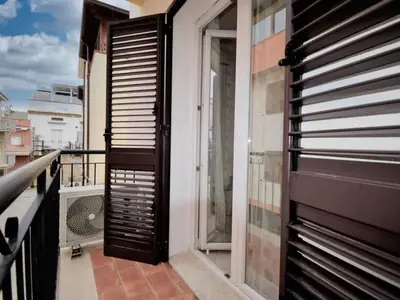 a balcony with a wooden door on a building at Onda Blu Apartment in Balestrate