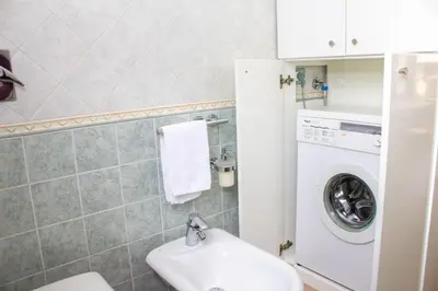 a bathroom with a toilet and a washing machine at euforbia in San Vito lo Capo