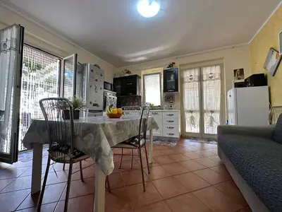 a kitchen with a table and chairs in a room at La Perla Di Campofelice in Campofelice di Roccella