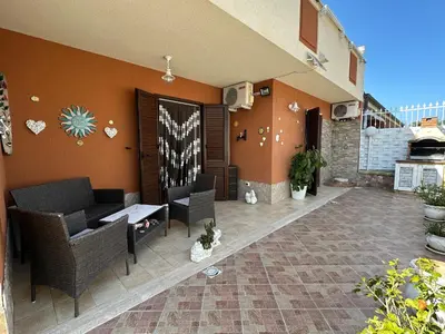 a patio with wicker chairs and a wall with hearts on it at La Perla Di Campofelice in Campofelice di Roccella