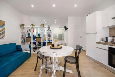 a living room with a blue couch and a table and chairs at Dream Holidays - Apartments in Palermo