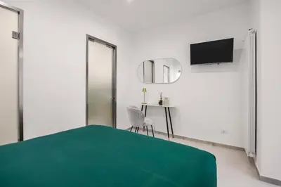 a white room with a green bed and a table at Dream Holidays - Apartments in Palermo
