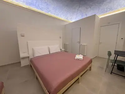 a bedroom with a large bed with two bags on it at La Piccola Formica in Palermo