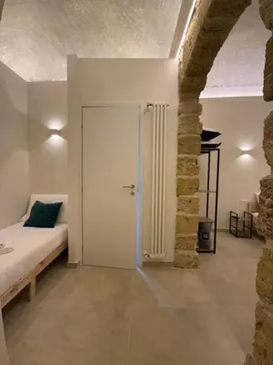 a bedroom with a bed and a door in a room at La Piccola Formica in Palermo