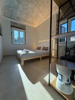 a bedroom with a bed in a room with windows at La Piccola Formica in Palermo