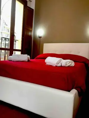 a white bed with two towels on top of it at Nonno Antonio's House in Palermo