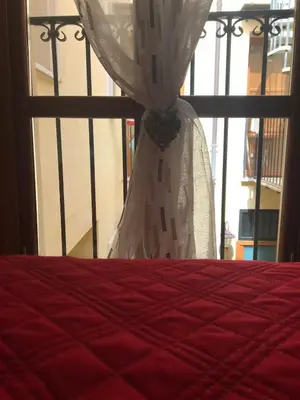 a bedroom with a bed and a window with a curtain at Nonno Antonio's House in Palermo