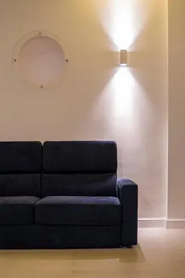 a blue couch in a living room with a light at Dimora Ballarò in Palermo