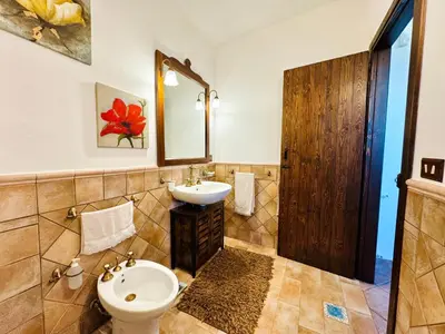 a bathroom with a sink and a toilet and a mirror at Villa Bellavista in Carini
