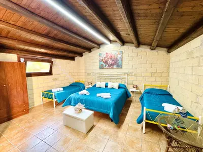 a room with two beds and tables in it at Villa Bellavista in Carini