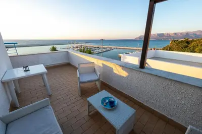 a balcony with a table and chair and the ocean at Baia Marina Oasi in Balestrate