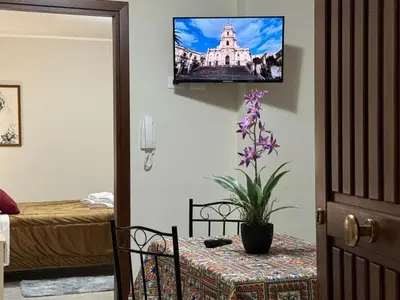 a room with a table and a tv on the wall at Maribu in Casteldaccia