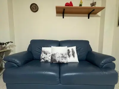 a blue leather couch with two pillows on it at Maribu in Casteldaccia