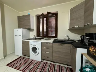 a kitchen with a washing machine and a refrigerator at Maribu in Casteldaccia