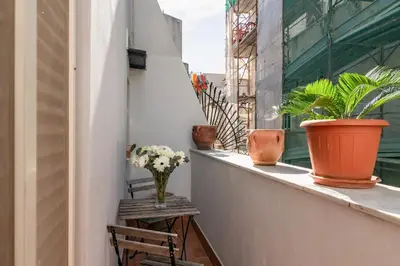 a balcony with a vase of flowers on a ledge at GuestHost - Casetta del Romito - Lovely Studios in Palermo
