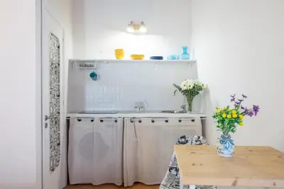 a kitchen with a sink and a table with flowers at GuestHost - Casetta del Romito - Lovely Studios in Palermo